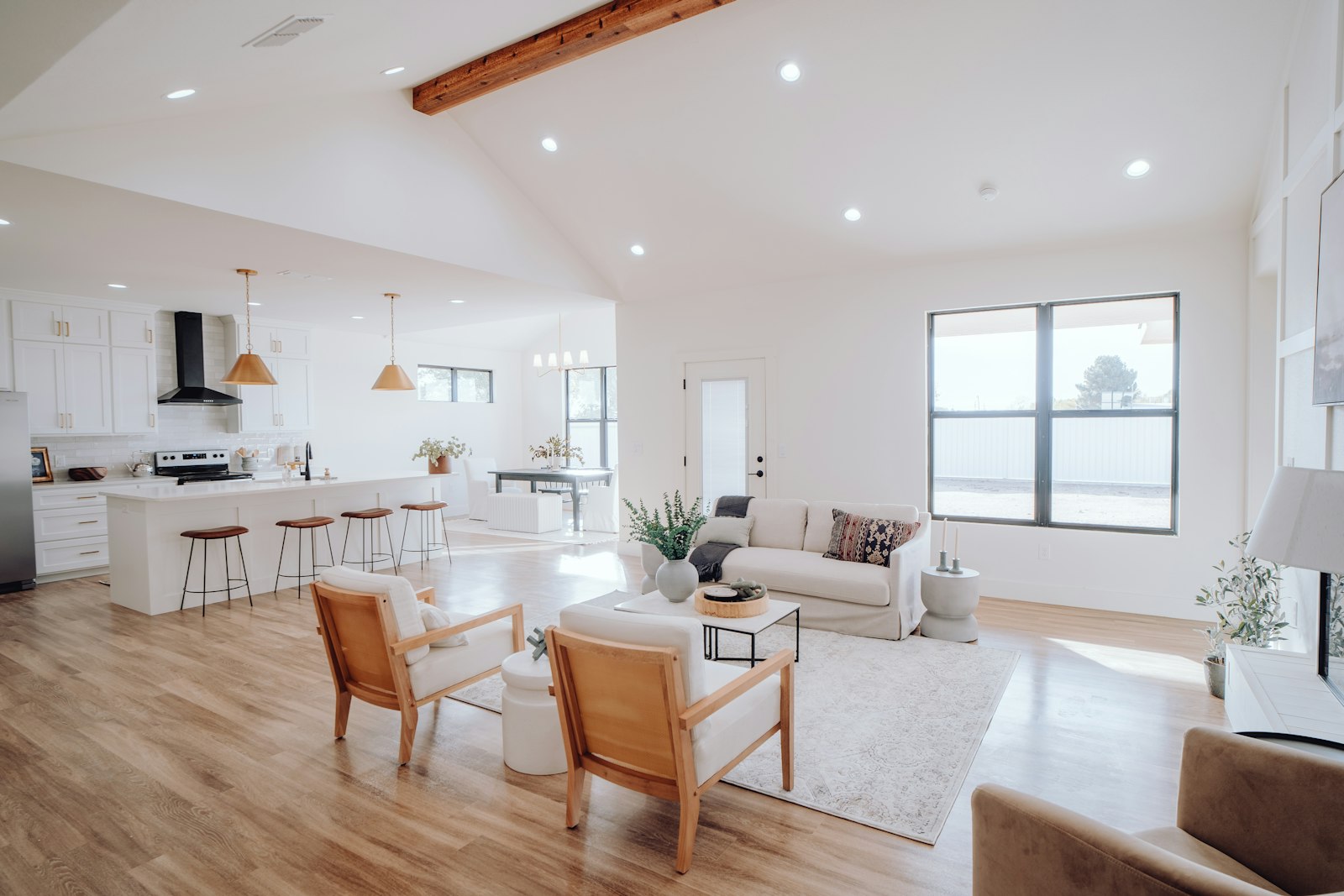 Bright open-plan furnished living room and kitchen with vaulted ceiling